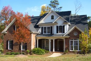 Single family residence in the fall with colorful leaves on the roof.