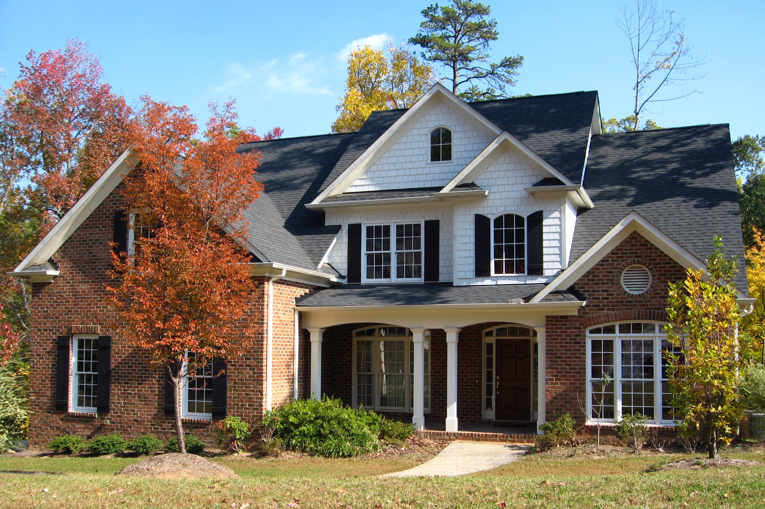 Single family residence in the fall with colorful leaves on the roof.